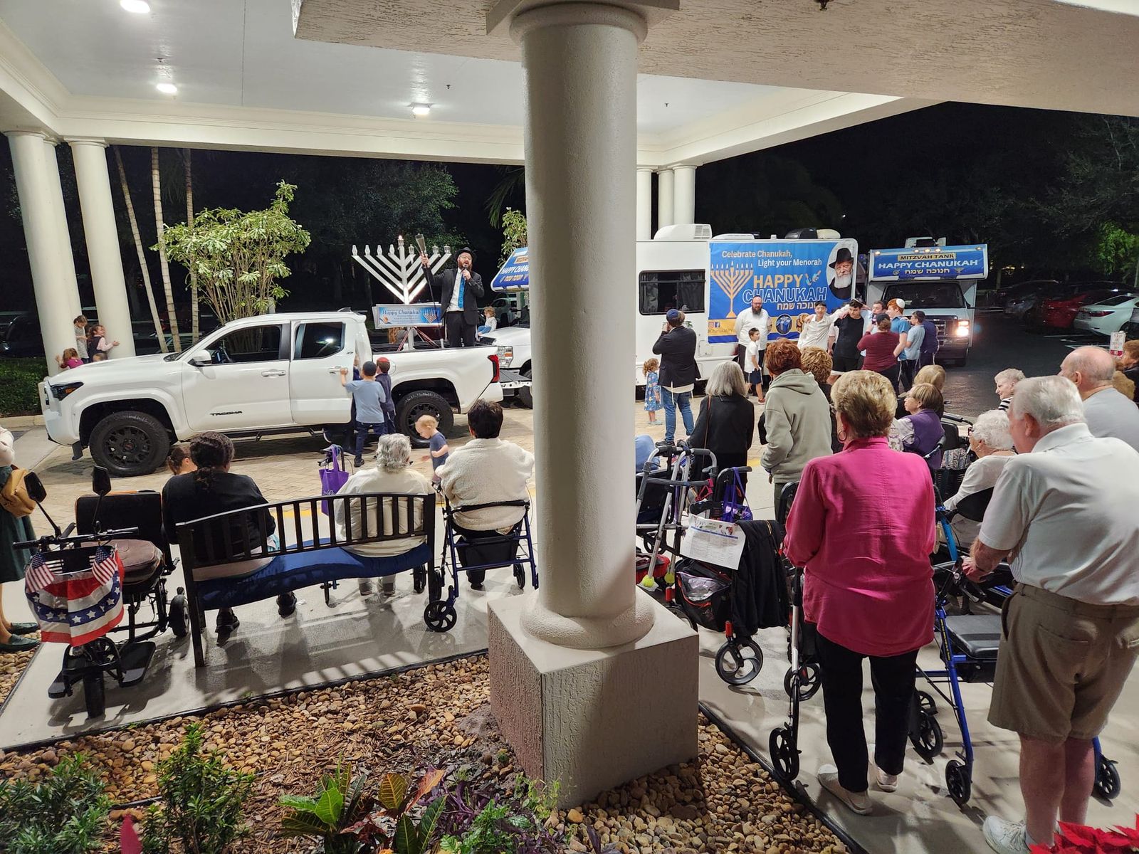 Senior residents celebrating menorah lighting in the evening